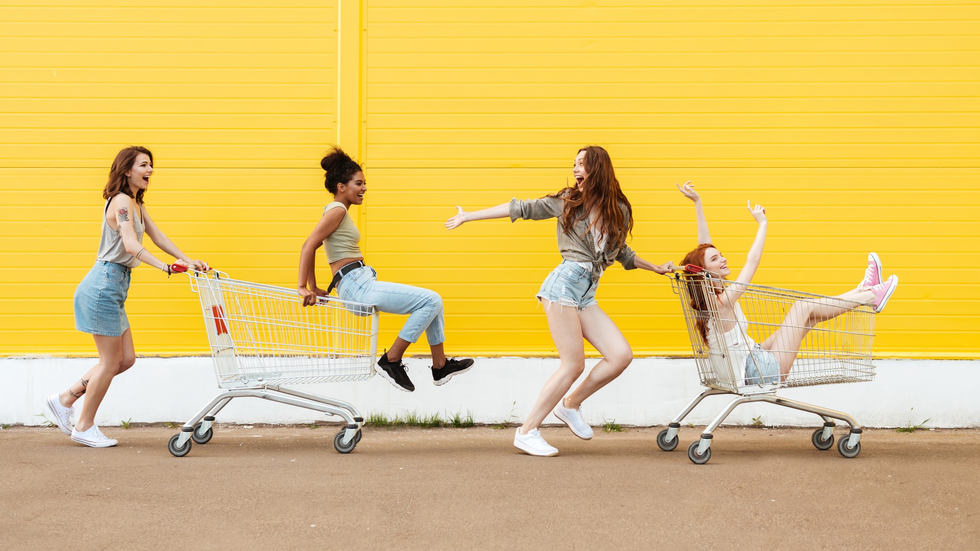 Teenager-Mädchen haben Spaß mit Einkaufwagen beim Shopping