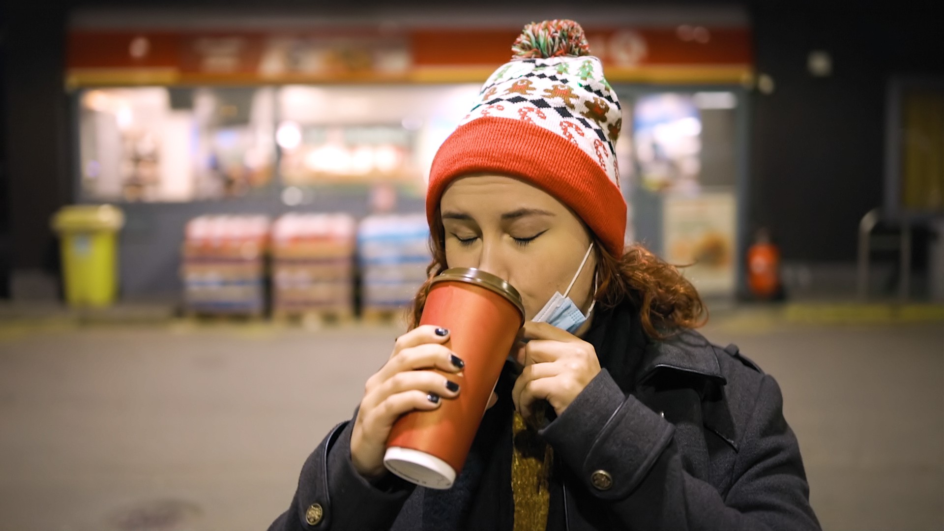 Frau im Freien  winterlich mit Weihnachtsmütze trinkt heißes Getränk aus Becher