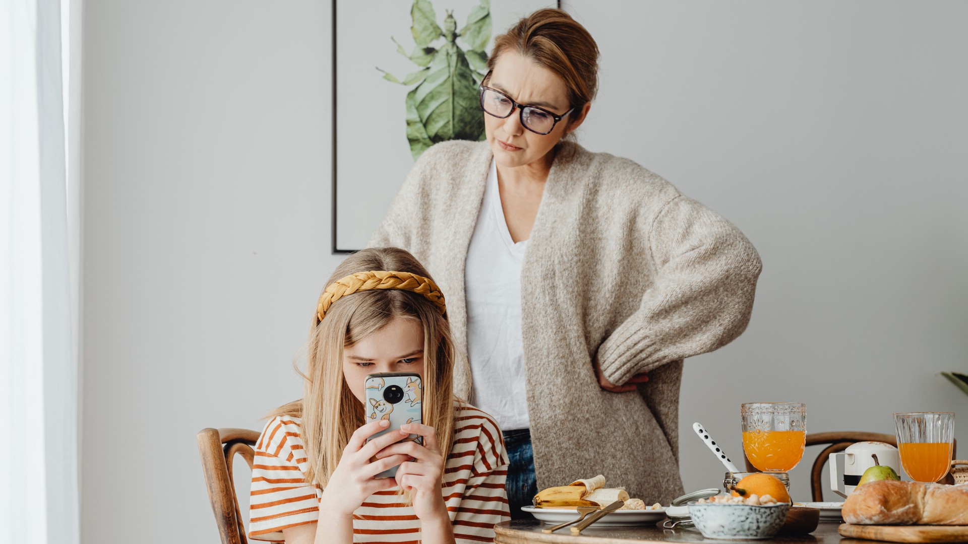 Kind mit Handy, besorgte Mutter