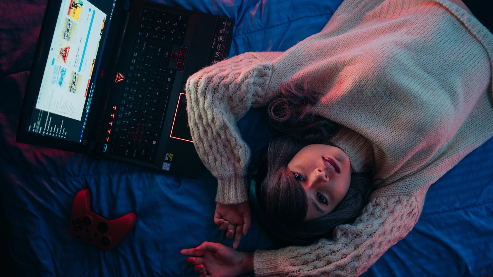 Erschöpftes Mädchen liegt in ihrem Bett mit Computer