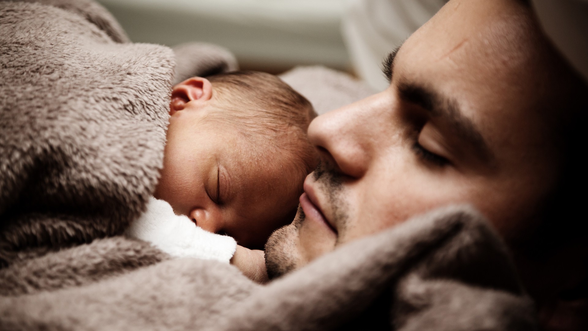 Vater hält schlafendes Baby